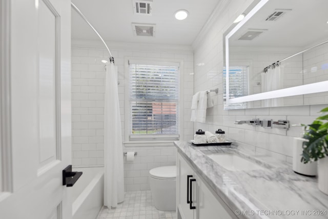 full bathroom with vanity, crown molding, toilet, tile walls, and shower / tub combo