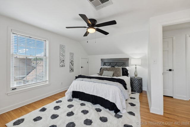 bedroom featuring ceiling fan, light wood-type flooring, and vaulted ceiling