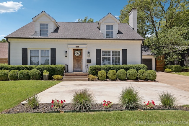 new england style home featuring a front lawn