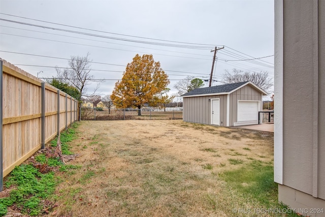 view of yard with a garage and an outbuilding