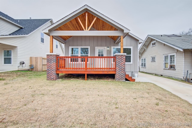 rear view of property with a yard and a wooden deck