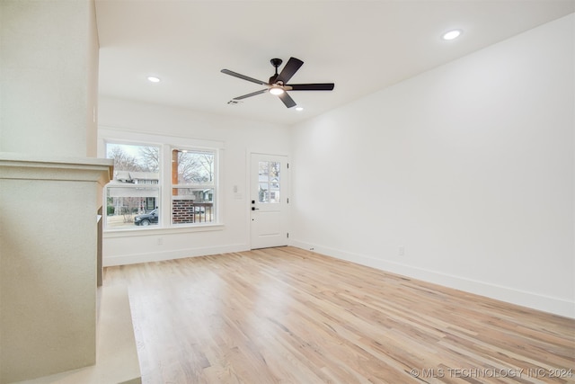 unfurnished living room featuring ceiling fan and light hardwood / wood-style flooring