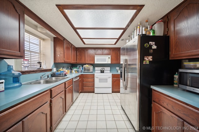 kitchen featuring a textured ceiling, sink, light tile patterned floors, and stainless steel appliances