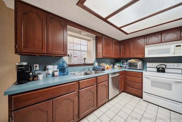 kitchen with light tile patterned floors, white appliances, a textured ceiling, and sink