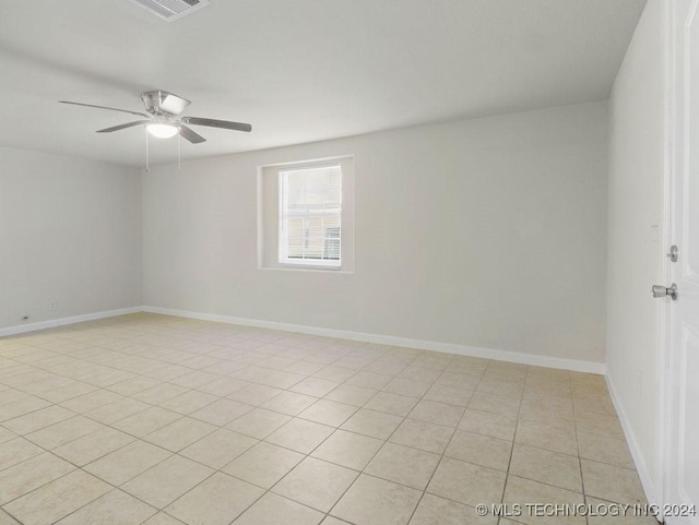 tiled spare room featuring ceiling fan