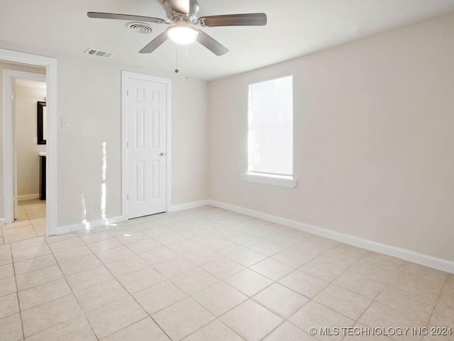 unfurnished bedroom with light tile patterned floors, ceiling fan, and a closet