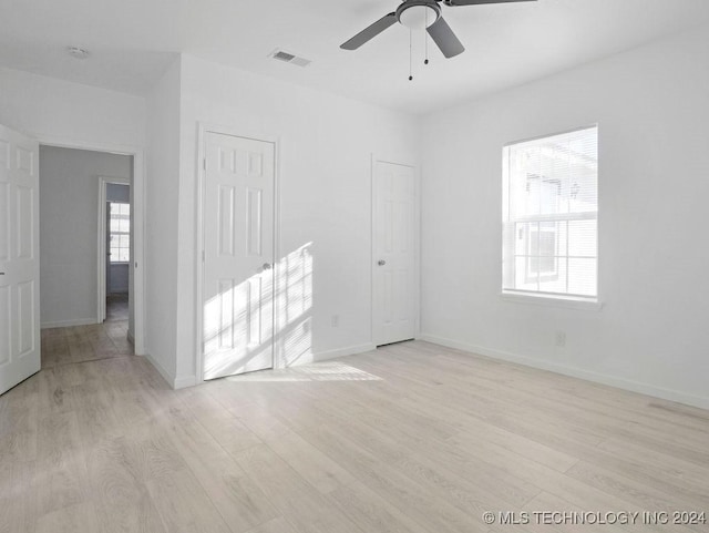 unfurnished room with ceiling fan, light wood-type flooring, and a healthy amount of sunlight