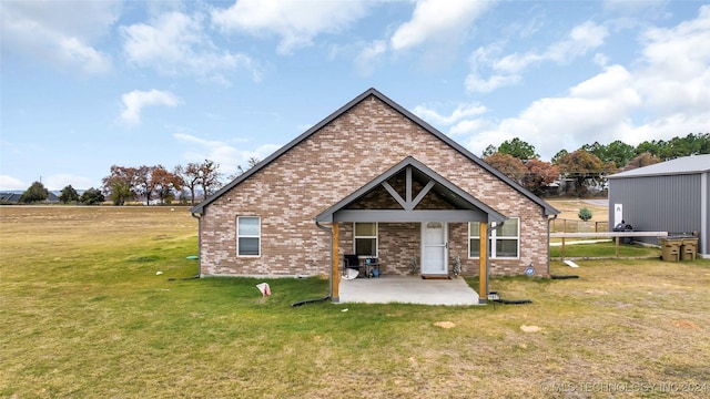 rear view of house with a lawn and a patio area