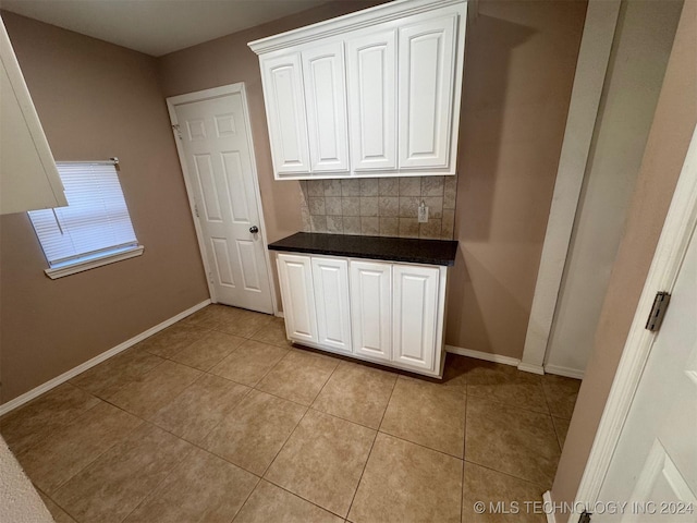 kitchen featuring white cabinets, decorative backsplash, and light tile patterned flooring