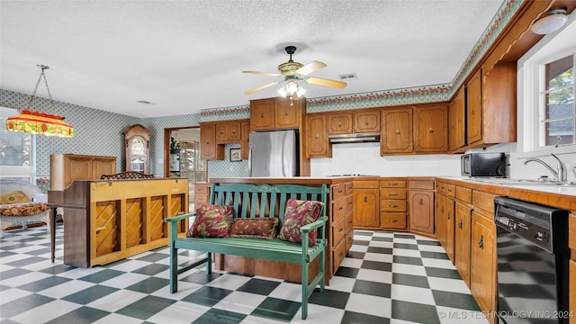 kitchen with black appliances, sink, ceiling fan, a textured ceiling, and decorative light fixtures
