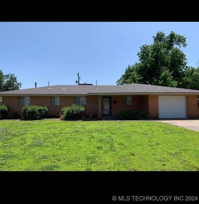 ranch-style house featuring a garage and a front lawn