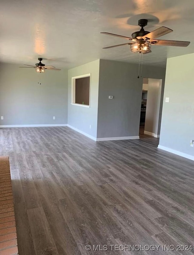 unfurnished living room with ceiling fan and dark wood-type flooring