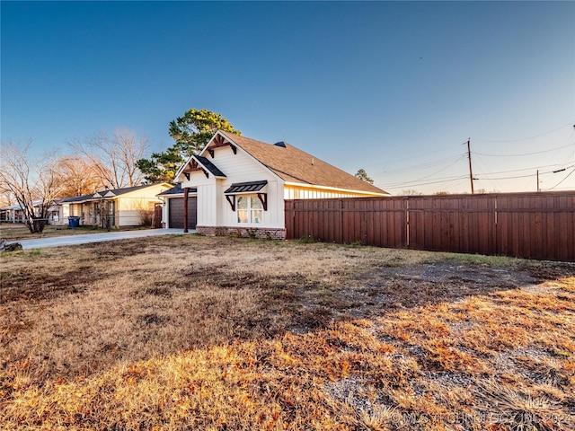 view of side of home with a yard and a garage