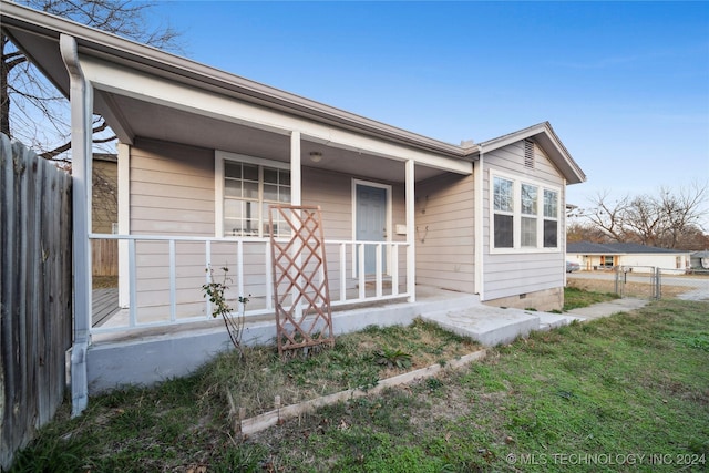 view of front of house featuring covered porch and a front lawn