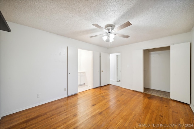 unfurnished bedroom featuring wood-type flooring, a textured ceiling, a closet, and ceiling fan