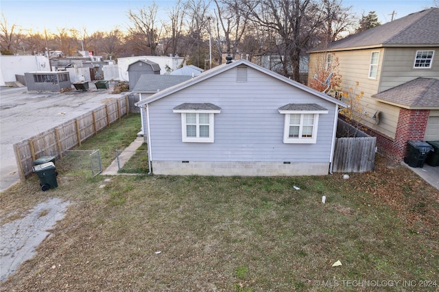 property exterior at dusk with a lawn