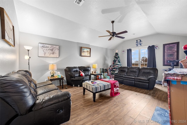 living room featuring hardwood / wood-style floors, ceiling fan, and vaulted ceiling