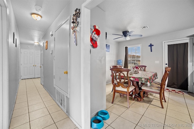 hallway featuring a textured ceiling and light tile patterned flooring