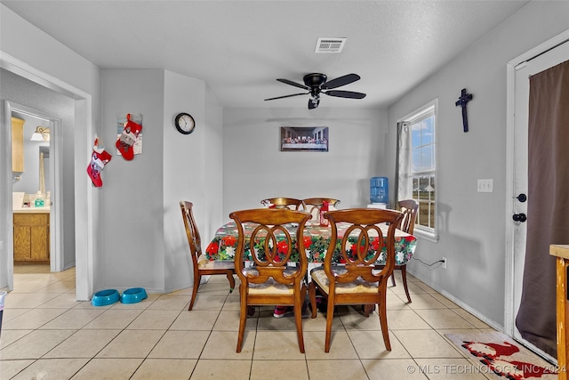 dining area featuring ceiling fan, light tile patterned floors, and a textured ceiling