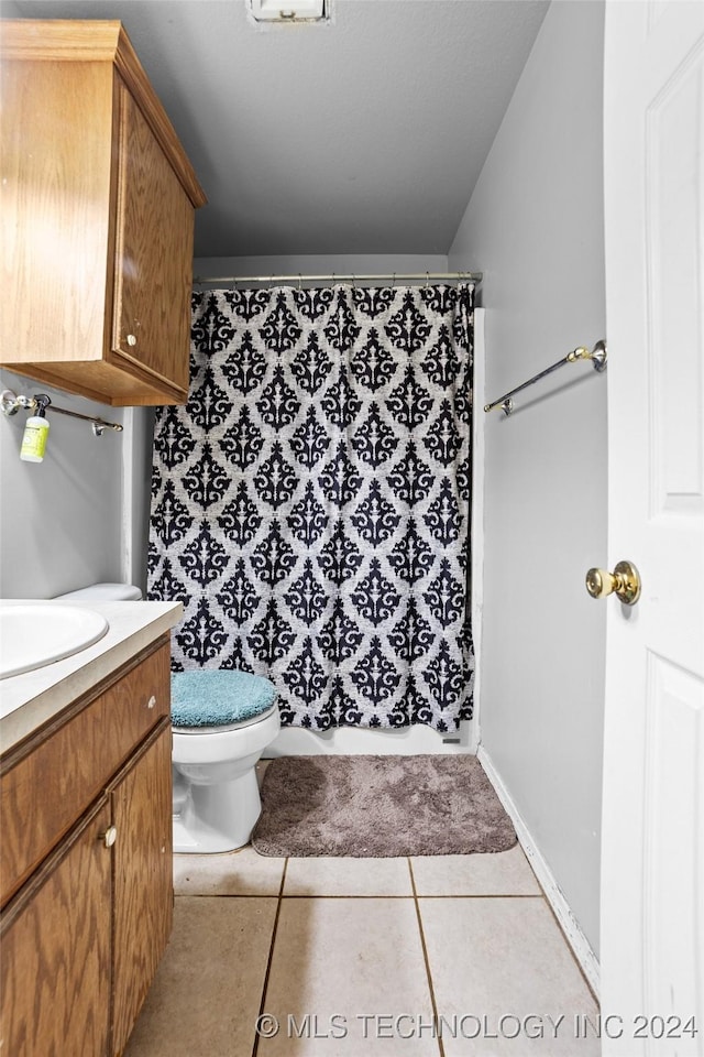 bathroom with tile patterned flooring, vanity, and toilet