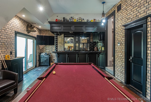 playroom with bar area, billiards, dark wood-type flooring, and brick wall