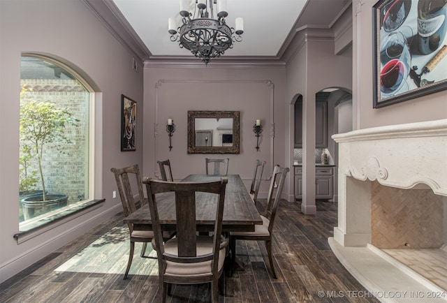 dining area featuring dark hardwood / wood-style flooring, crown molding, and a chandelier