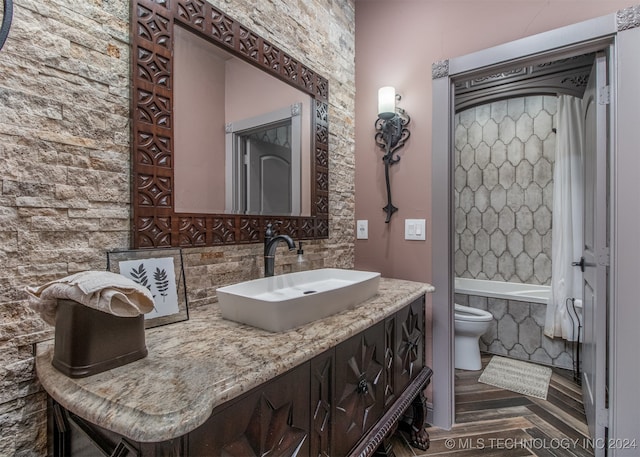 bathroom with hardwood / wood-style floors, a bathtub, toilet, and vanity