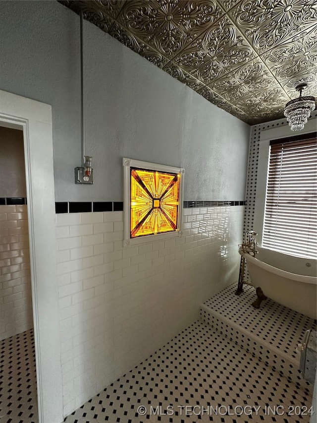 8 W Main St, Ardmore, OK 73401 - full bathroom featuring tile walls, a freestanding bath, a wainscoted wall, and an ornate ceiling