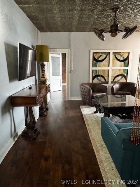 unfurnished living room featuring ceiling fan and dark wood-type flooring