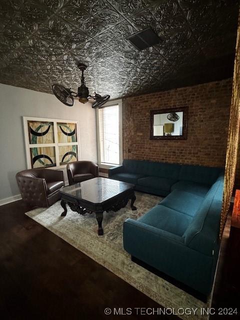 living room with ceiling fan, brick wall, and wood-type flooring