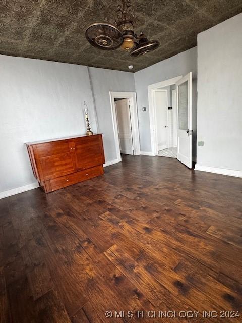 8 W Main St, Ardmore, OK 73401 - unfurnished living room with a chandelier, an ornate ceiling, and wood finished floors
