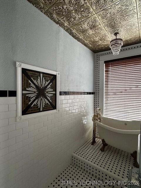 bathroom featuring a bath and tile walls