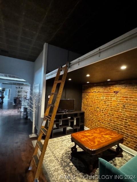 interior space with hardwood / wood-style flooring and brick wall