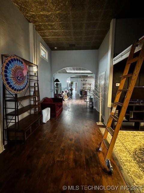 corridor featuring hardwood / wood-style floors and a towering ceiling