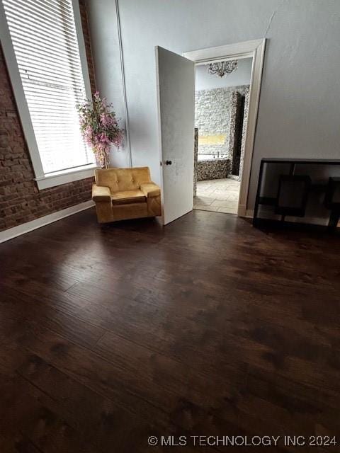 interior space featuring dark hardwood / wood-style flooring and brick wall