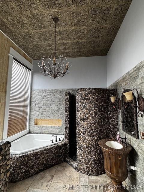 bathroom featuring a washtub, vanity, a chandelier, and tile walls