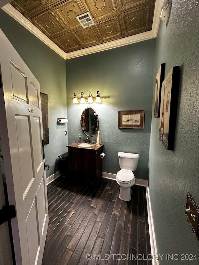 bathroom featuring hardwood / wood-style floors, vanity, toilet, and crown molding