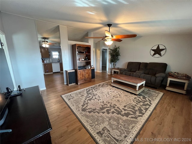 living room with ceiling fan, hardwood / wood-style floors, and vaulted ceiling