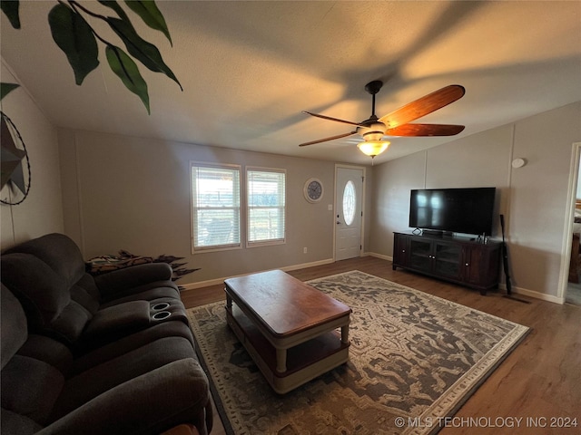 living room with hardwood / wood-style flooring, ceiling fan, and lofted ceiling