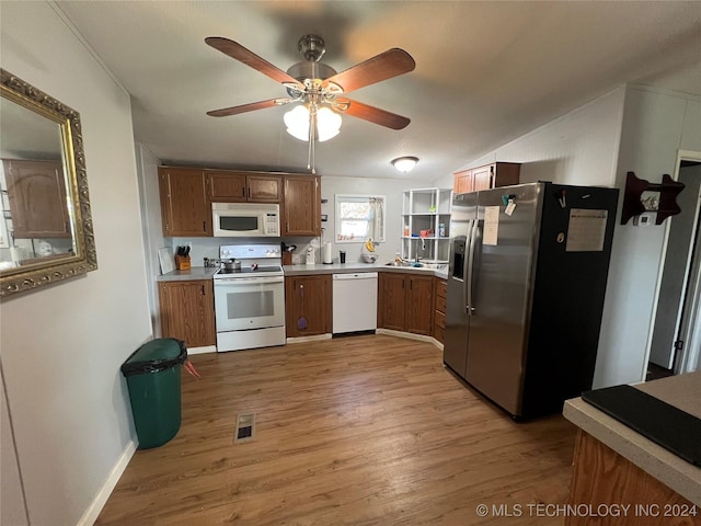 kitchen with light wood-type flooring, white appliances, vaulted ceiling, ceiling fan, and sink