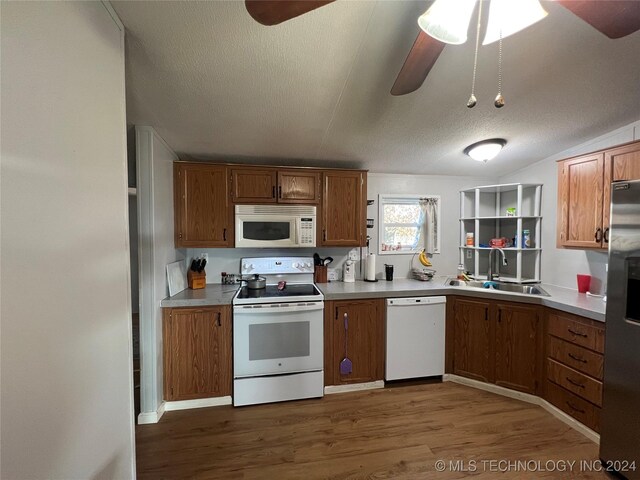 kitchen featuring a textured ceiling, white appliances, ceiling fan, sink, and hardwood / wood-style flooring