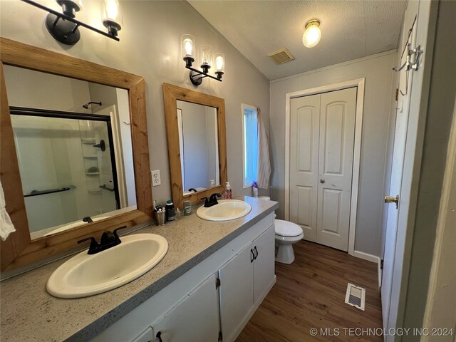 bathroom with wood-type flooring, vaulted ceiling, a textured ceiling, an enclosed shower, and vanity