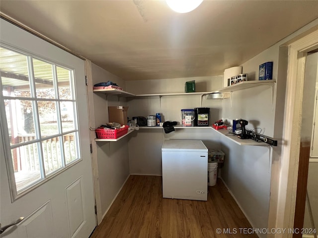 interior space featuring dark hardwood / wood-style flooring, refrigerator, and white cabinetry