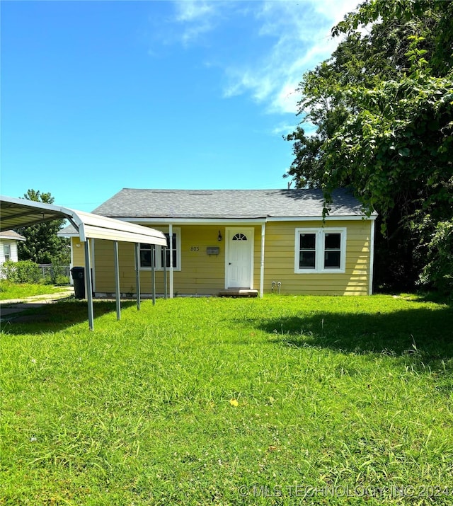 view of front of house featuring a front lawn and a carport