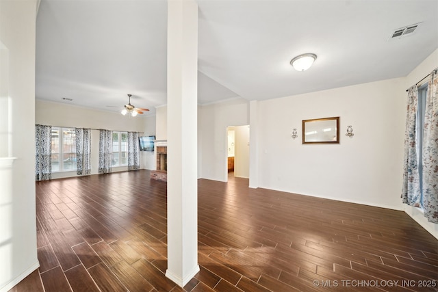 unfurnished room with ceiling fan and a fireplace