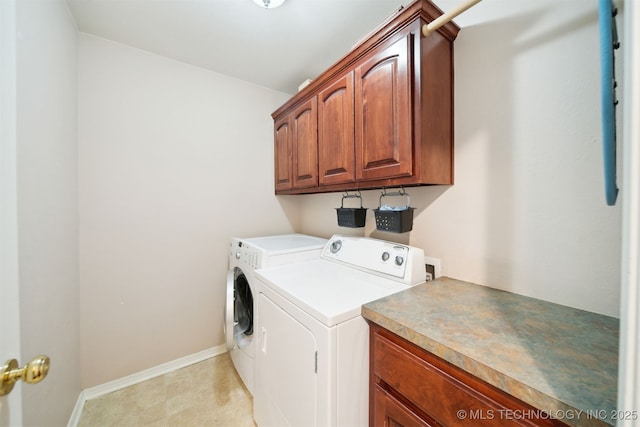 washroom with cabinets and washer and dryer