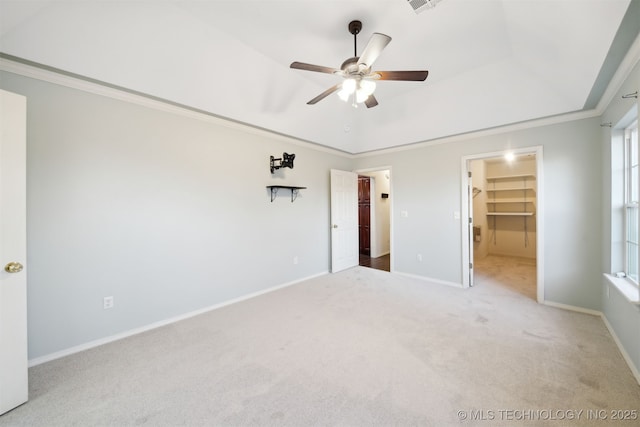 unfurnished bedroom featuring ceiling fan, carpet floors, ornamental molding, a spacious closet, and a closet