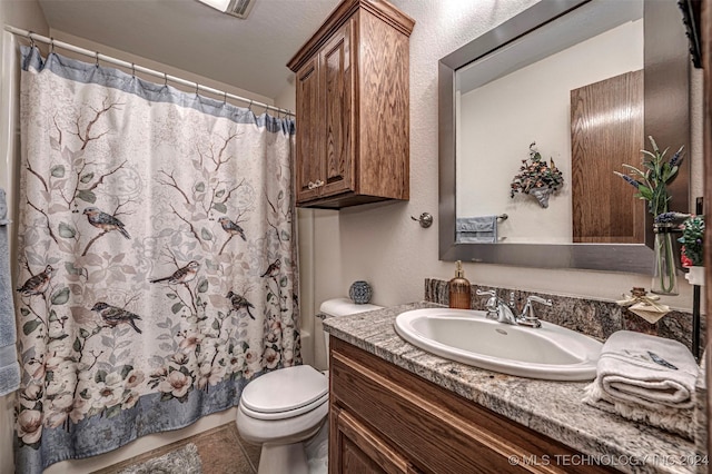 bathroom featuring tile patterned floors, vanity, and toilet