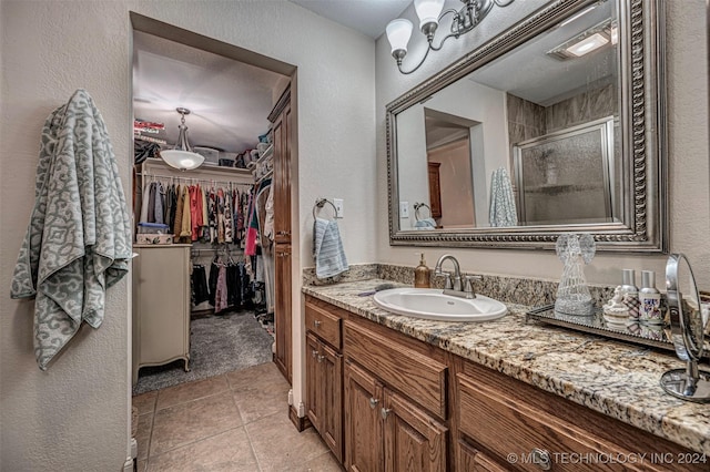 bathroom featuring tile patterned flooring, vanity, and an enclosed shower