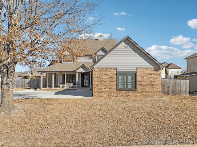 rear view of house with a lawn and a patio